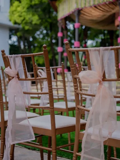Guest chairs decorated with simple, elegant pink ribbons.