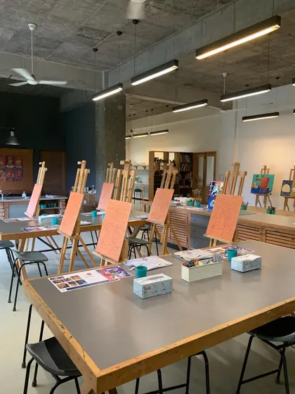 The studio is all set up with easels for an adult painting workshop. We create a relaxing and inspiring atmosphere for adults to unwind, learn about artists like Picasso, and explore their own creativity.