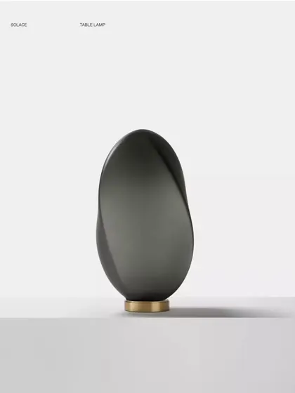 A studio shot of the bronze glass Solace lamp, its swirling, asymmetrical shape creating a captivating sculptural object.