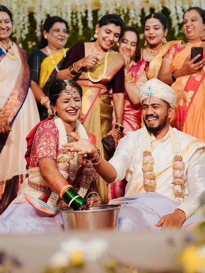 A fun-filled moment during the wedding games, with the bride and groom laughing as they search for the ring.