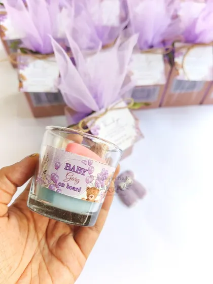 A close-up of the final packaged gift box for a baby shower, held in hand to show its lovely size and presentation.