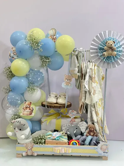 Another view of the baby arrival hamper, showing the thoughtful arrangement of gifts, from the plush cat and elephant toys to the neatly arranged clothing and balloon decorations.