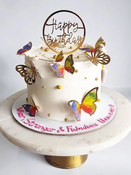 Sometimes, simple elegance is all you need. This white cake adorned with colorful butterflies is a beautiful and understated way to say 'Happy Birthday'.