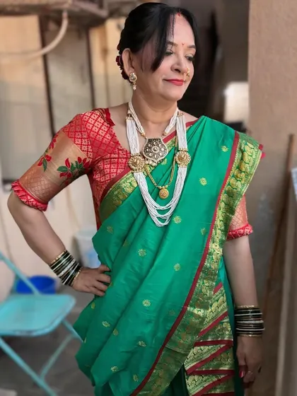 The full Maharashtrian look. The green saree with the red border is a classic combination, and the makeup is kept elegant and timeless.