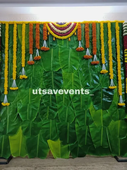 A simple and elegant backdrop made entirely of banana leaves and marigold flower garlands. This is a perfect choice for an eco-friendly and traditional South Indian event.