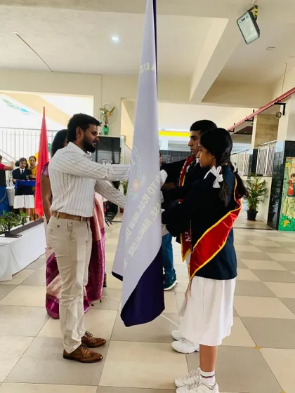 Handing over the house flag during the investiture ceremony. This symbolizes the passing of responsibility and the trust placed in new leaders.