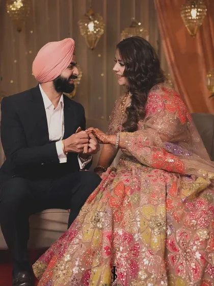 Love is in bloom! For their Sangeet, we styled the bride in a stunning floral lehenga and coordinated the groom's look by matching his pagg to the colors in her outfit.