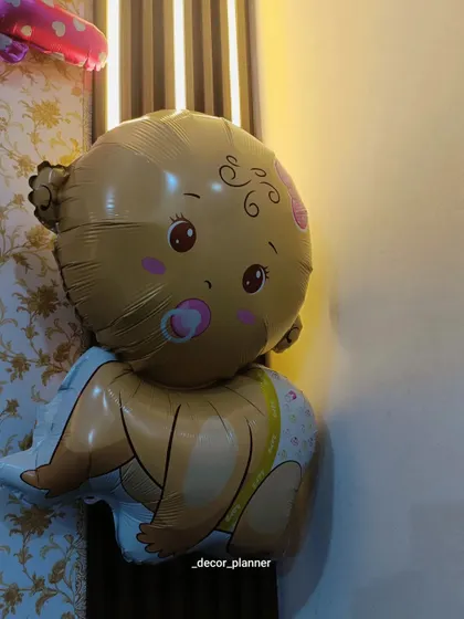 A close-up of the cute baby-shaped foil balloon used in the welcome home decor. These themed balloons are a fun and essential part of creating a baby-focused celebration.