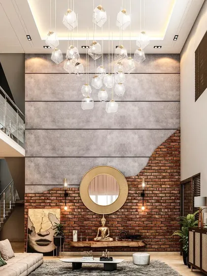 This living room in a duplex villa features a unique blend of industrial and rustic elements. The exposed brick wall contrasts with a concrete-finish panel, all brought together by a stunning cascade of glass pendant lights.
