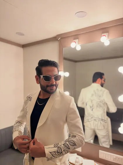 Getting ready for another night of Garba in a custom white suit with beautiful black embroidery. The mirror check is a must.