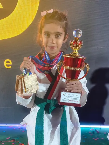 An incredible achievement. Pahal proudly displays her four gold medals and the 'Best Team' trophy from the championship in Pune.
