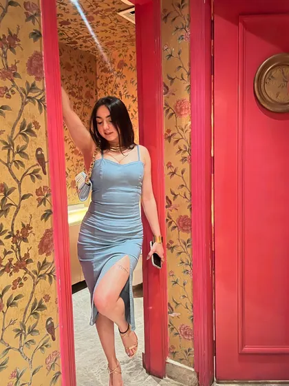A dangerous combination: a beautiful dress and a pretty face. Posing in a gorgeous blue dress against a floral wallpaper, feeling confident and chic.