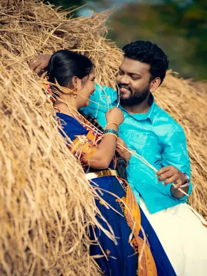 A playful and rustic pre-wedding photo of a couple interacting in a haystack, full of laughter and natural charm.