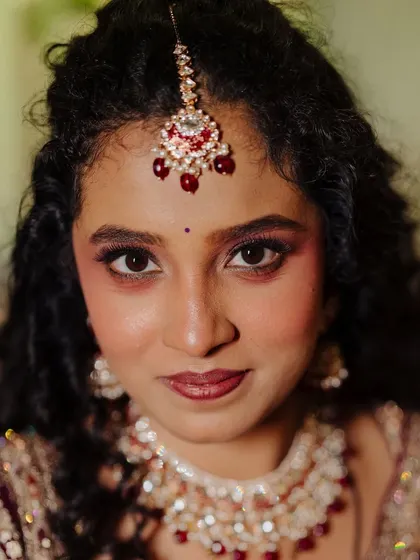 A royal reception look for a curly-haired bride. The soft glam makeup is paired with her enhanced natural curls for timeless elegance.