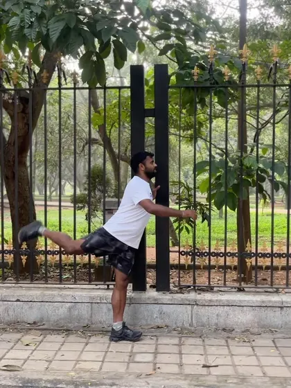Demonstrating leg swings, a dynamic warm-up drill to open up the hips and prepare the hamstrings for a run.