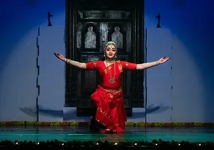 A final pose of offering at the feet of the Lord, framed by a set designed to look like a temple entrance.