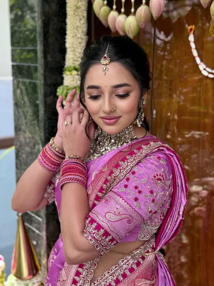A candid moment of the bride adjusting her earring. The makeup is soft and dewy, perfect for a daytime ceremony.