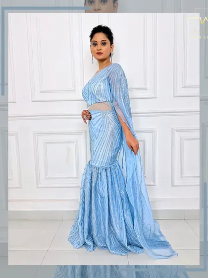 A side view of the ice-blue gown, showing the sheer, sparkling cape detail.