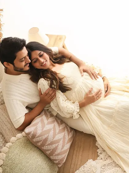 A relaxed and cozy portrait of the couple lying down amidst soft pillows and blankets in our boho studio. This angle offers a unique and intimate perspective on their connection.
