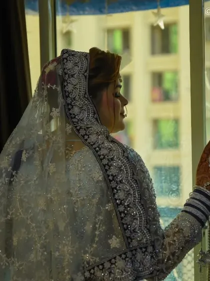 A side profile of the bride looking out the window, lost in thought. This candid, moody style of photography tells a story and captures the quiet moments of the day.