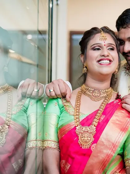 A creative reflection shot of a couple, capturing their joy and the beautiful colors of their outfits.