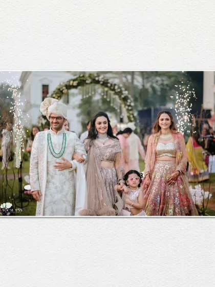 A beautiful family moment during the groom's entrance, captured in a wide format that feels like a still from a movie.