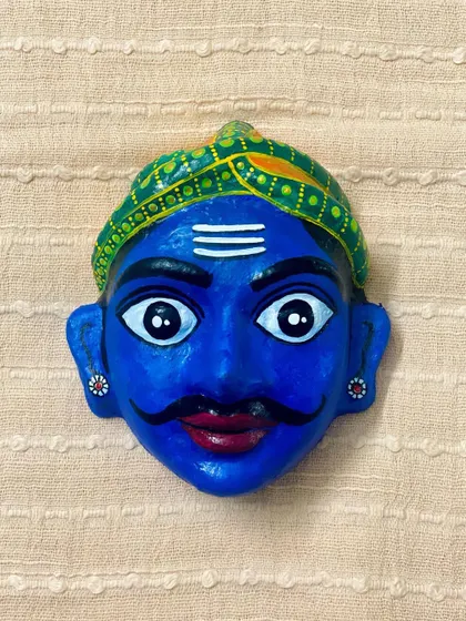 A small, hand-painted mask of a man's face with a mustache and turban. This quirky and colorful piece is another example of my affordable art, perfect for gifting.