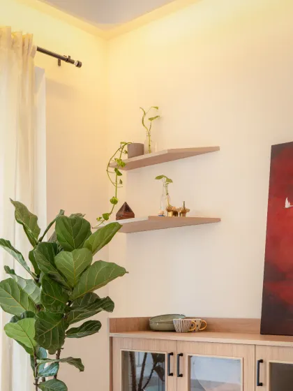 A curved ceiling, a bright red painting, and a lively fig plant are all the ingredients needed for a cozy dining corner. We deliberately kept the crockery unit subtle with glass shutters to ensure the attention is on what's placed inside, not the unit itself.