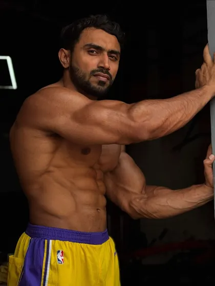 Side pose, showing the arm and oblique definition.