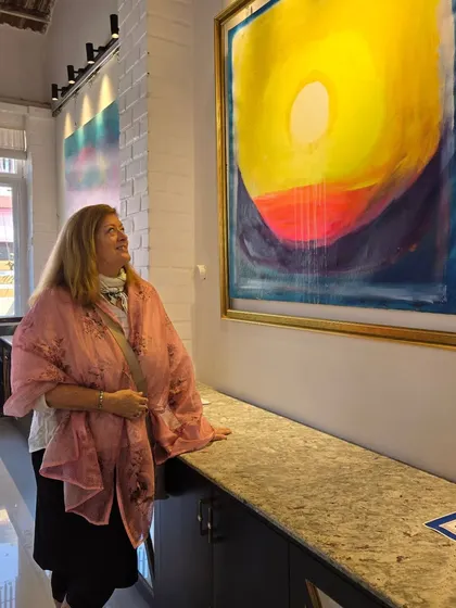 A visitor admires a large, vibrant abstract painting during Gurpreet Kaur's solo exhibition. We are proud to showcase the work of talented emerging artists.