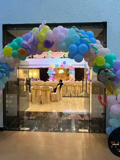 A sweet and colorful candy-themed entrance arch. I used pastel balloons and props like donuts and ice cream cones to welcome guests to this fun birthday party.
