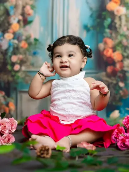 A candid moment where the baby seems to be listening intently, with her hand up to her ear. We love these unscripted shots.