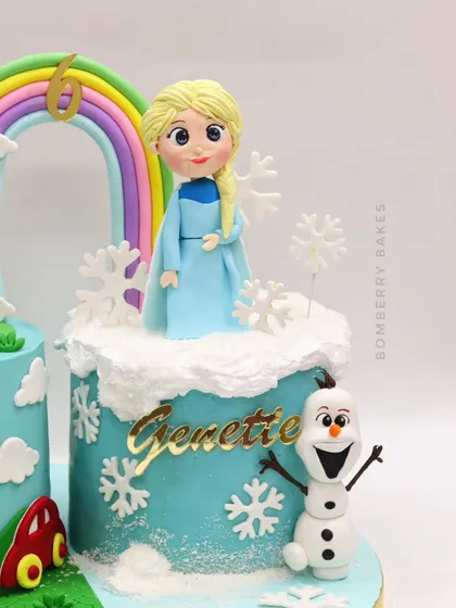 A full view of the Elsa side of the twin's cake. This shows how the fondant character, buttercream "snow," and snowflake details come together to create a winter wonderland scene.