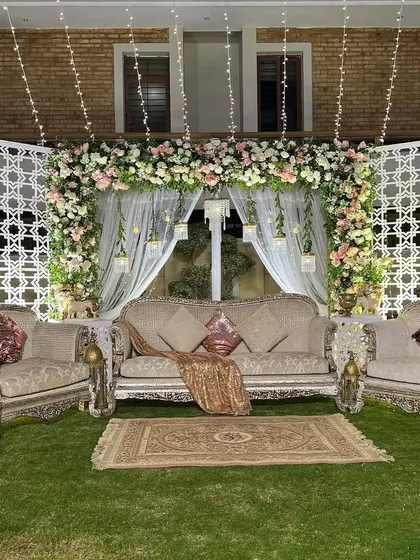 The elegant outdoor stage setup at night. The fairy lights and warm uplighting transform the space into a cozy and magical setting for an evening celebration.