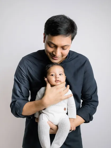 A sweet moment as a newborn wakes up and looks at their father.