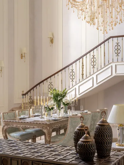 A close-up of the dining area and grand staircase in The Ivory Royale. This image highlights the intricate railing design and the carefully selected decor, which celebrate Indian craftsmanship within a classical framework.