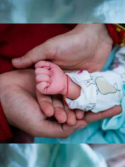 A newborn's hand wrapped around a parent's finger, showcasing the delicate and strong bond from the very beginning.