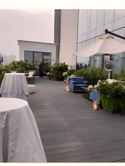 A chic rooftop lounge setup for a corporate event or cocktail party. The open-air setting with comfortable seating and high-top tables creates a relaxed and modern atmosphere.
