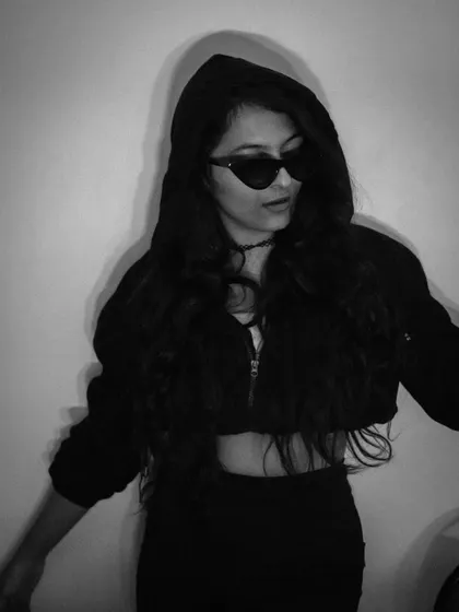 A variation of the hooded, mysterious look. This pose, with the sunglasses slightly lowered, adds a hint of curiosity and attitude to the dark aesthetic.