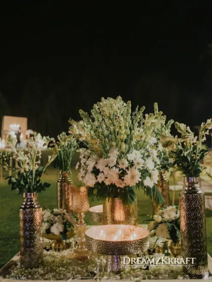 For a soulful Sufi night, we used a palette of ivory, white, and gold. This centerpiece with white tuberoses and brass vases, set against a canopy of fairy lights, perfectly captured the serene and spiritual mood.