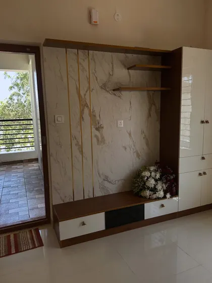 A full view of a living room project from different angles. We painted the walls in a neutral beige that pairs well with the white and wood entertainment unit, creating a warm and modern feel.