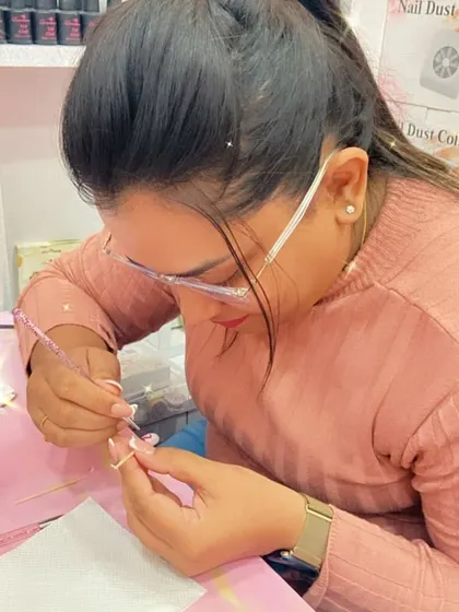 With steady hands, a student applies a bead of acrylic, a crucial moment in creating a flawless nail extension.
