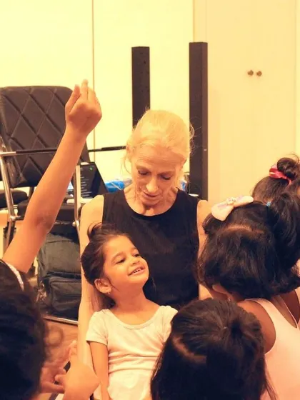 A student raises her hand, eager to participate. We encourage curiosity and active involvement in our classes, creating a dynamic learning environment.