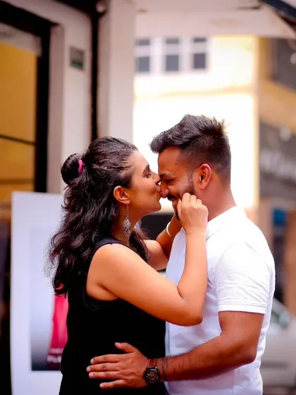 A sweet, candid moment on a city street during a pre-wedding shoot. The almost-kiss and natural interaction make this a warm and romantic photograph.