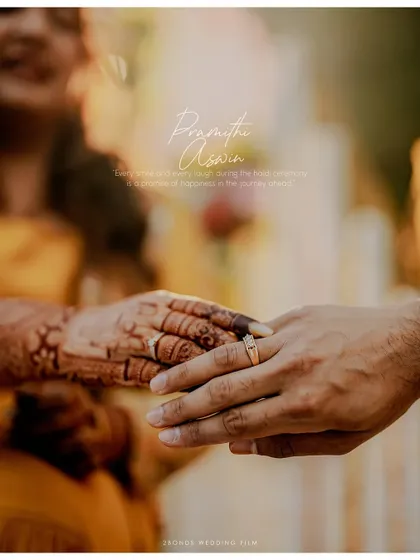 An artistic close-up of the couple's hands, showcasing the bride's intricate henna and their engagement rings.