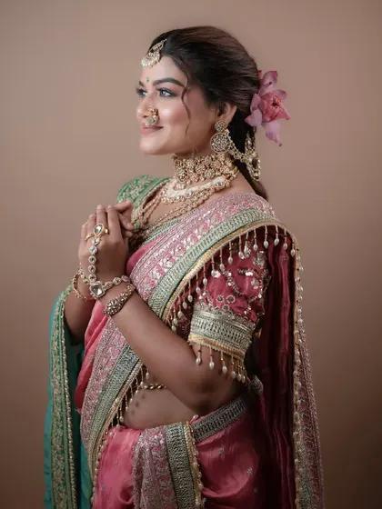 This three-quarter view highlights the intricate jewelry and the soft, elegant makeup that enhances the bride's natural beauty.