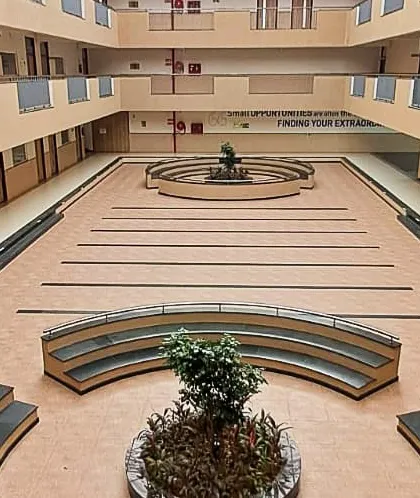 The central atrium of the EuroSchool campus, designed as a multi-functional common area. This expansive, naturally lit space encourages student interaction and hosts school events, featuring tiered seating and open corridors across multiple floors.