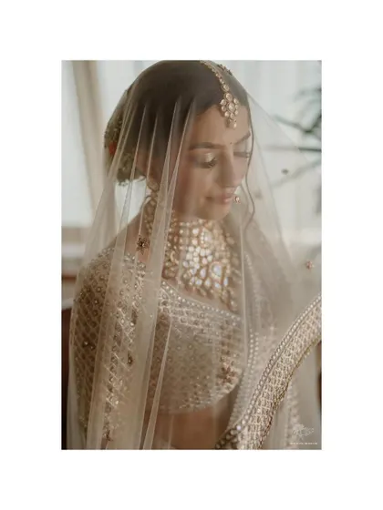 A delicate portrait of the bride under her veil. The soft light and her gentle expression create a timeless and romantic image, capturing her quiet beauty.