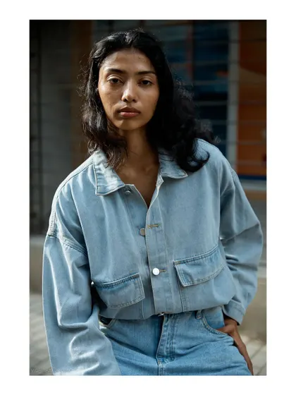 A close-up portrait from the street style session. The direct gaze and simple, urban background create a raw and honest headshot for a model.