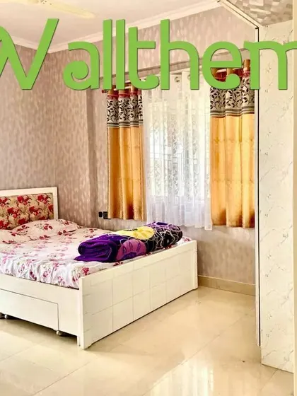 A bedroom with two different wallpaper designs, one textured and one floral, showing how patterns can be coordinated in a single room.